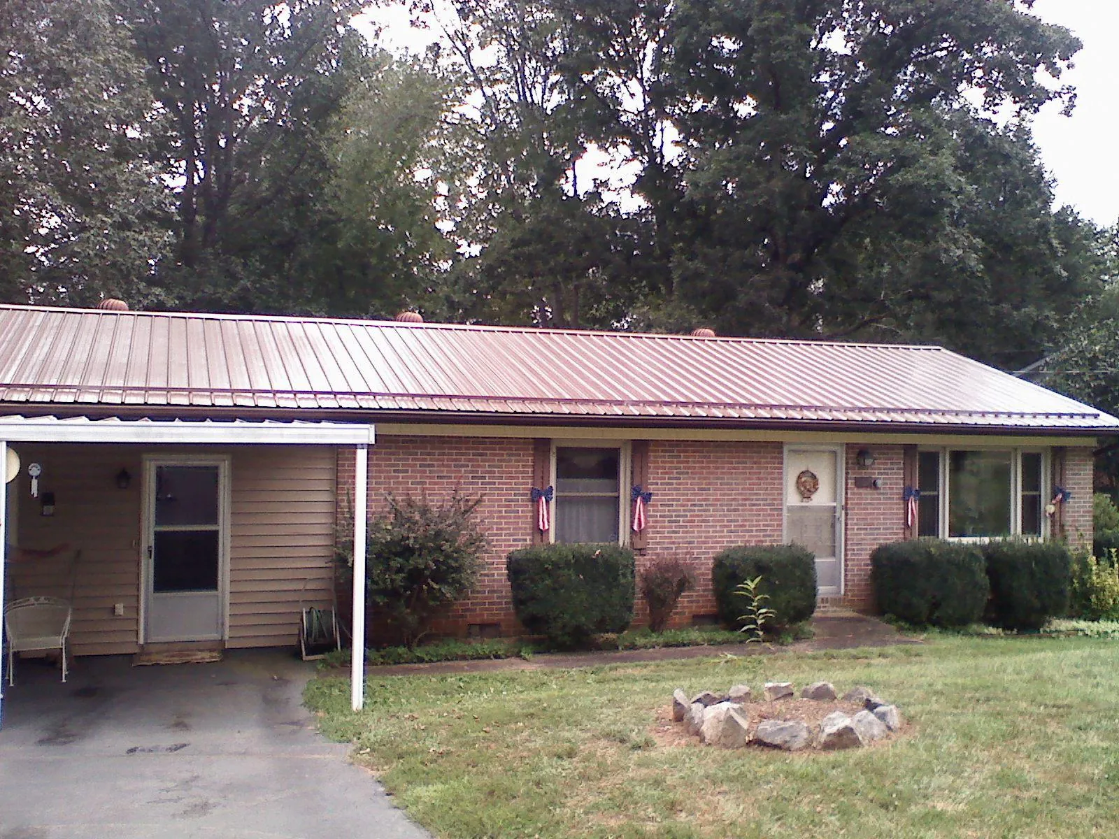 Bronze metal roof and carport on a brick ranch home — Roof Repair work by our crew in Priest River